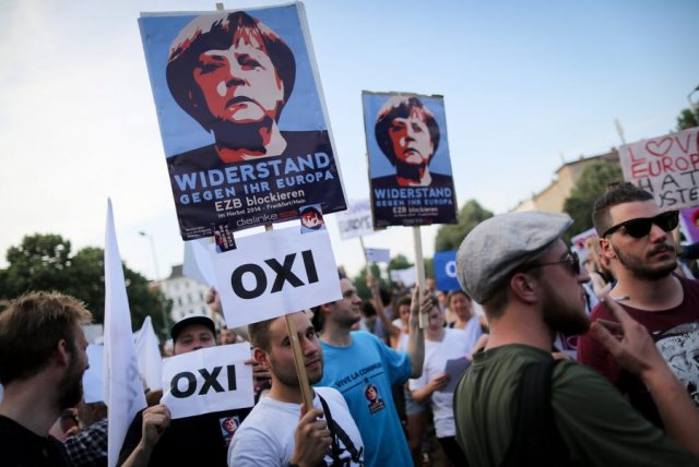 epa04829931 People carry placards depicting German Chancellor Angela Merkel and 'OXI' (No) signs during a demonstration in Berlin, Germany 03 July 2015, gathering supporters of the 'No' voting in the Greek referendum to be held on 05 July. The rally of several hundred demonstrators was held under the theme 'Nein!Oxi!No! to austerity - Yes to democracy.' EPA/KAY NIETFELD